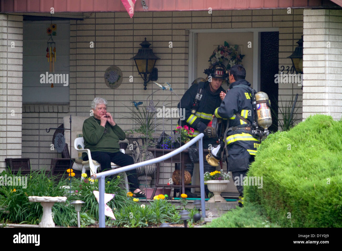 Les pompiers d'aider un résident au cours d'une maison en feu à Boise, Idaho, USA. Banque D'Images