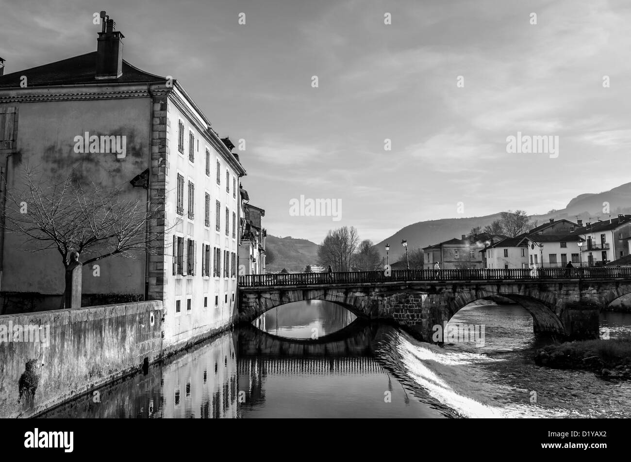 Les personnes qui franchissent le pont de pierre sur la rivière Salat à St Girons, Midi-Pyrenees, France. Noir et blanc. B&W Banque D'Images