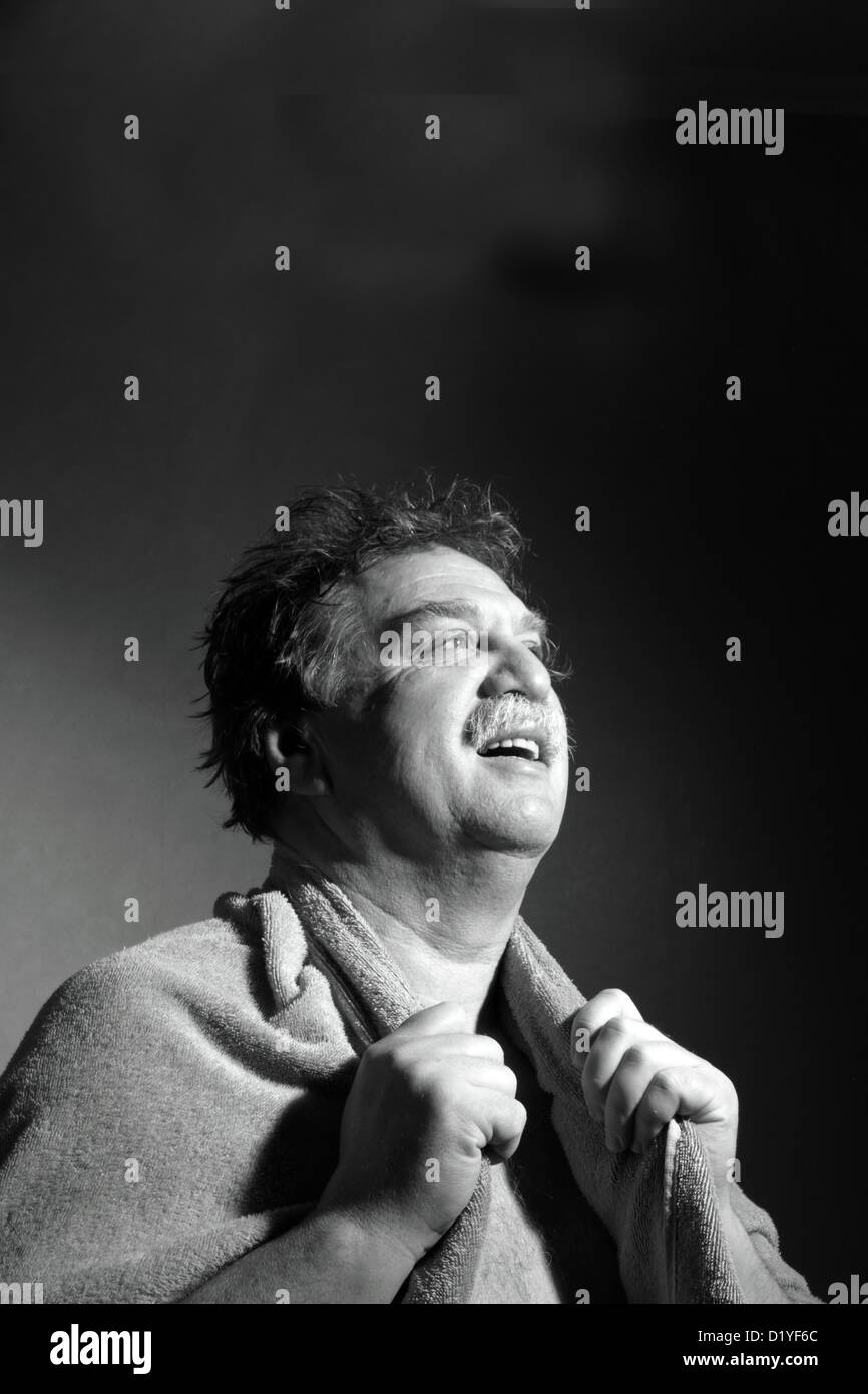 Homme d'âge moyen avec une serviette hors de la salle de bains Banque D'Images