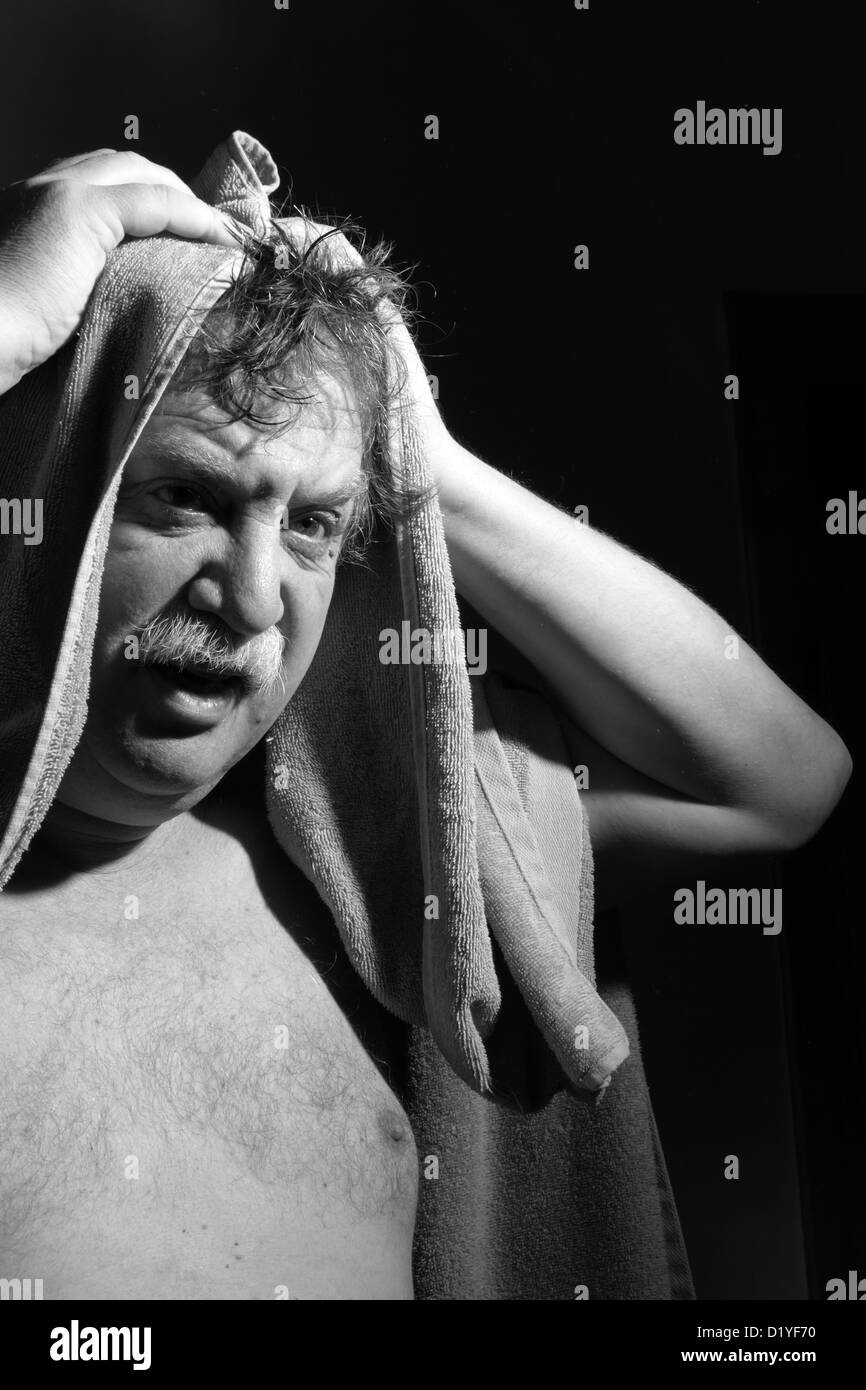 Homme d'âge moyen avec une serviette hors de la salle de bains Banque D'Images