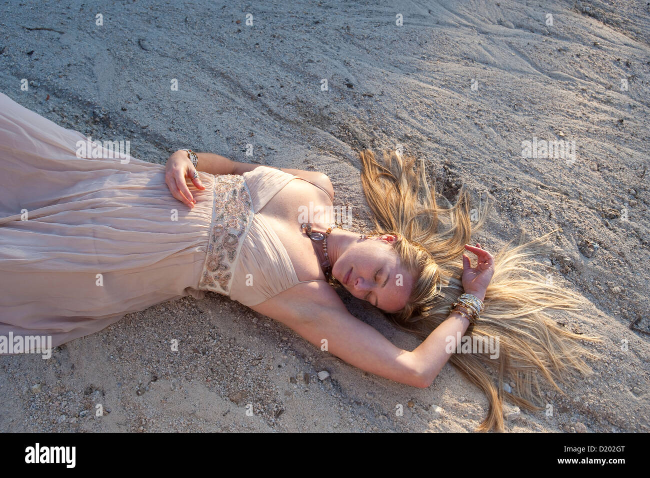 Woman lying in dry river run dans une belle robe. Banque D'Images