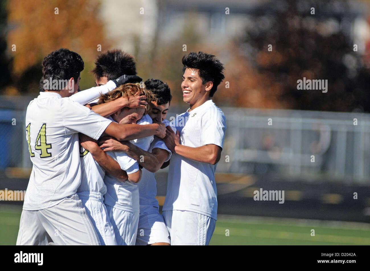 Joueurs de football célébrer à la suite d'un but pendant un match de l'école secondaire. USA. Banque D'Images