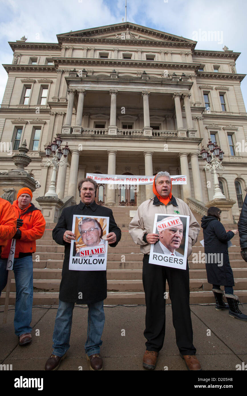 Lansing, Michigan - Le jour de l'ouverture de la session législative de 2013 dans le Michigan, les membres de l'Union européenne l'entrée de ligne de la capitale de l'Etat dans ce qu'ils appelaient une marche de la honte. Ils protestaient contre un "droit au travail" qui a été à la hâte dans les derniers jours de la session législative de 2012. Beaucoup d'entre eux tenu photos de législateurs républicains qui ont voté pour la loi. Banque D'Images