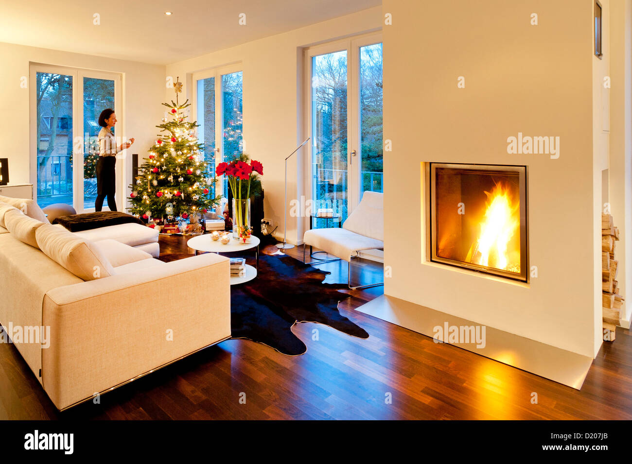 L'arbre de Noël moderne avec télévision et cheminée, jeune femme s'habiller l'arbre, Hambourg, Allemagne Banque D'Images