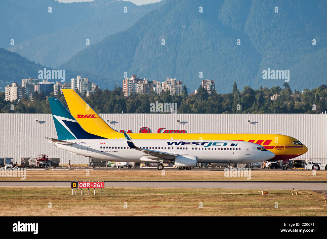 Un Boeing 737 de WestJet (737-800) un avion de passagers circule au cours des Boeing 767 cargo de DHL Air Cargo (exploité par ABX Air) Banque D'Images