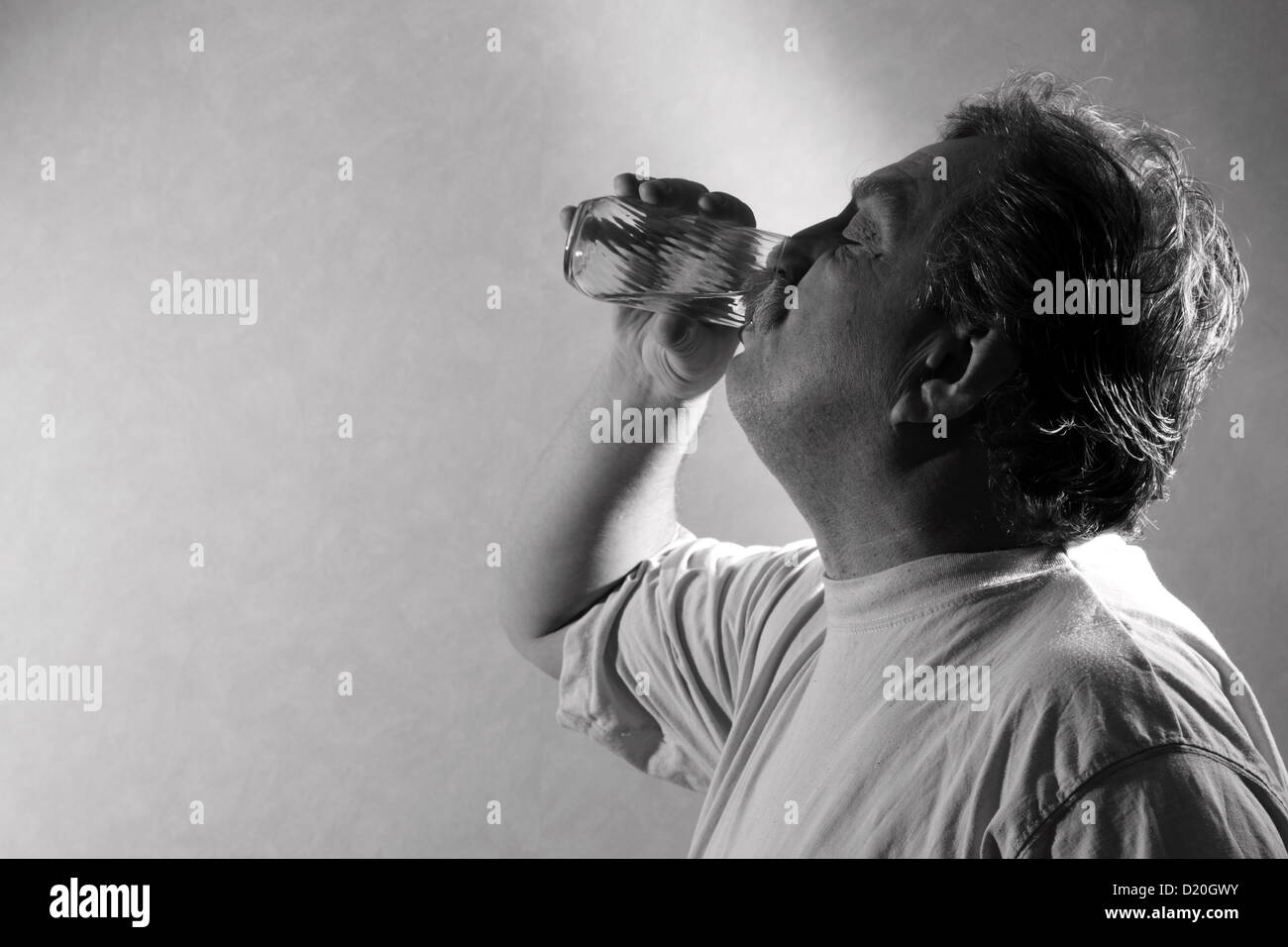 Homme d'âge moyen de boire un verre d'eau Banque D'Images