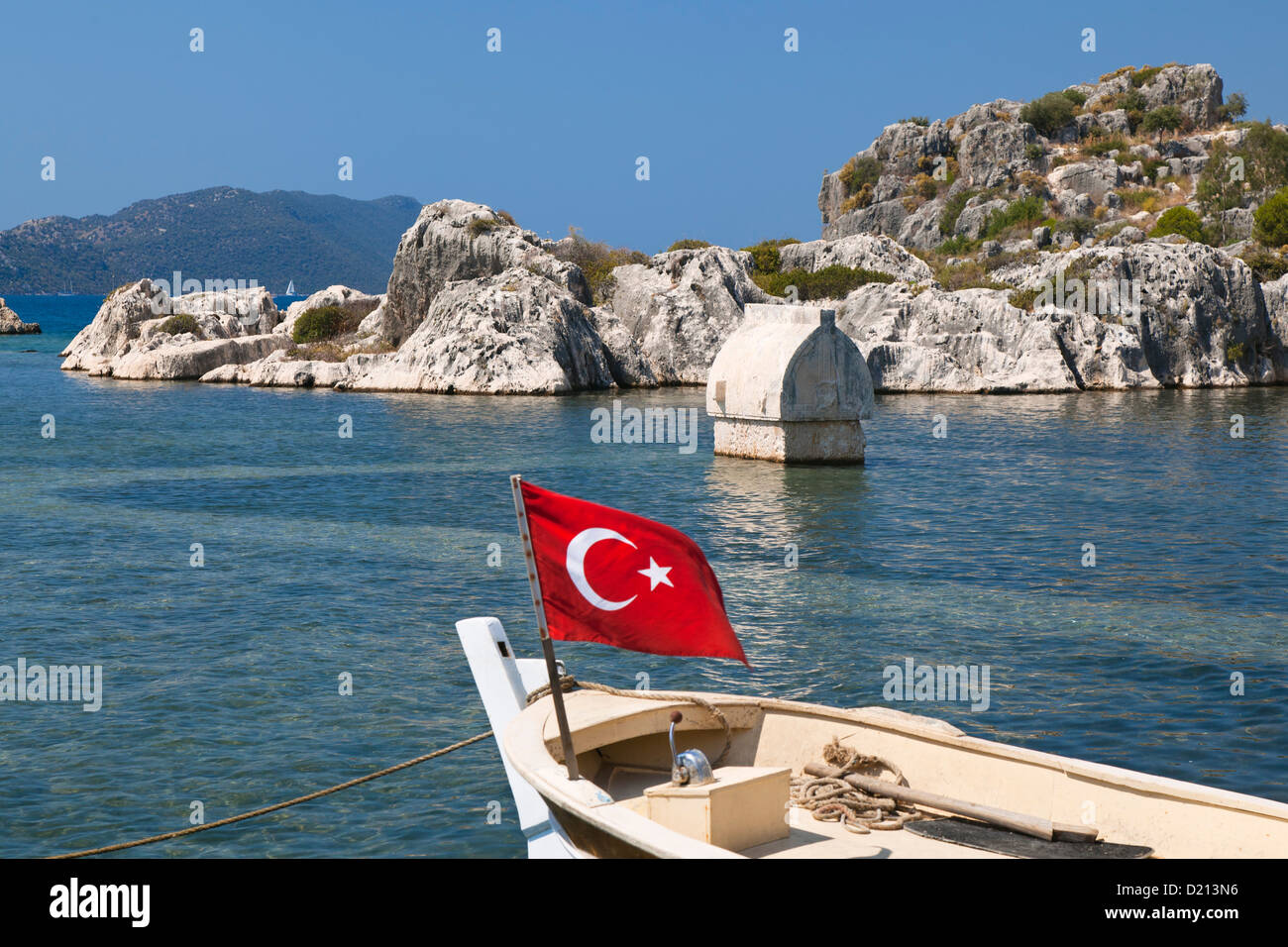 Bateau avec drapeau turc, sarcophage, Simena, Kalekoy, côte lycienne, Mer Méditerranée, Turquie Banque D'Images