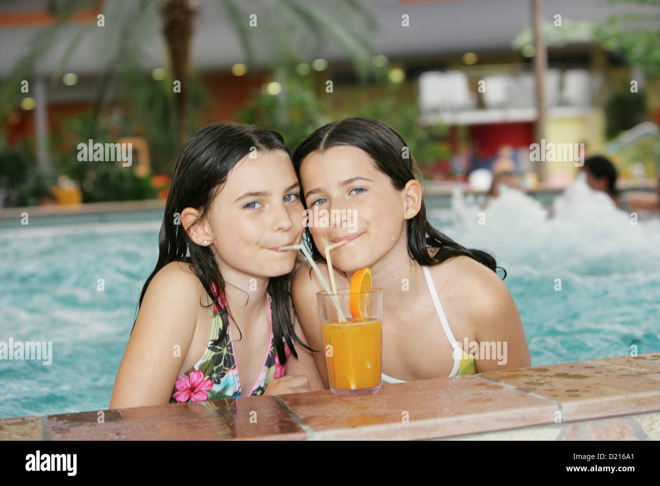 Deux filles boire du jus dans un pool, Bad Waltersdorf, Styrie, Autriche Banque D'Images