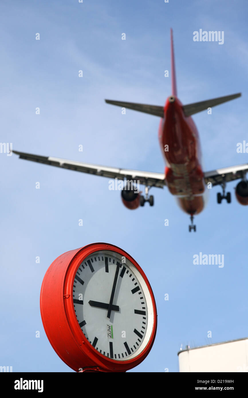 Berlin, Allemagne, un avion volant à basse altitude en survolant une horloge Banque D'Images