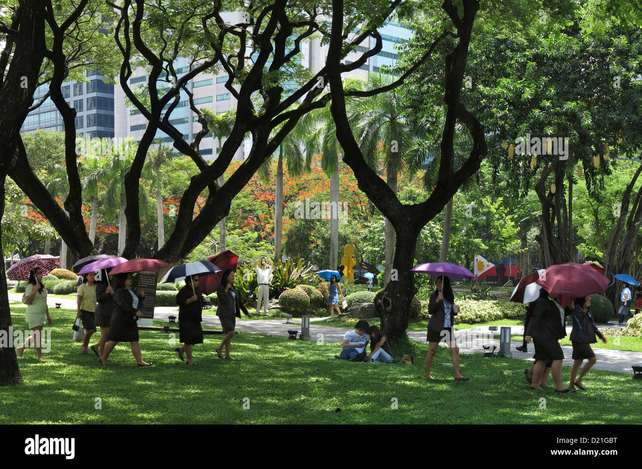 Les femmes avec des parapluies, Ayala Triangle Park de la ville de Makati, l'île de Luzon, Philippines, Asie Banque D'Images