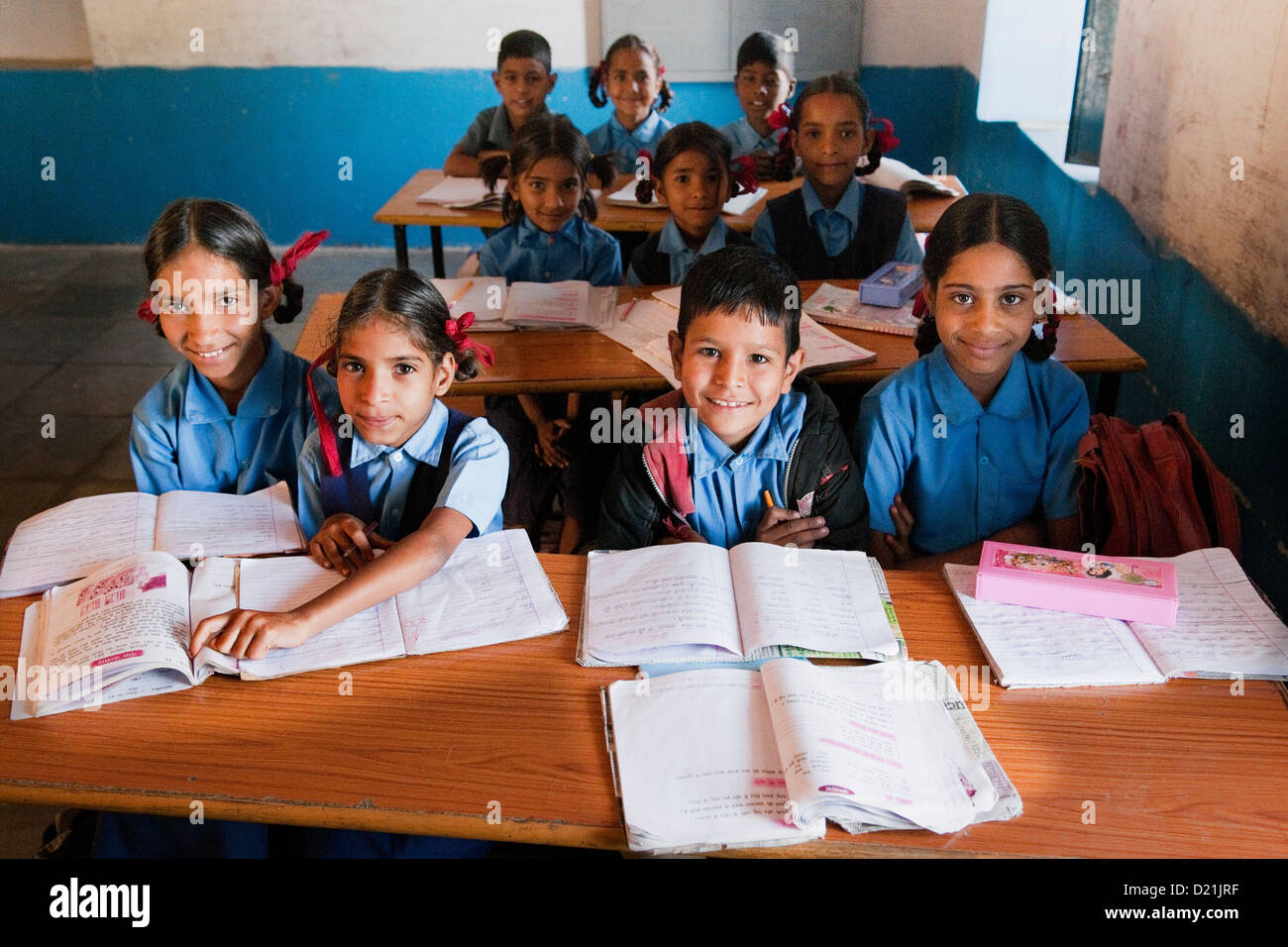 Smiling boy and girl les élèves du primaire en uniformes bleus dans une salle de classe d'une école primaire près d'Udaipur Rajasthan Inde Banque D'Images