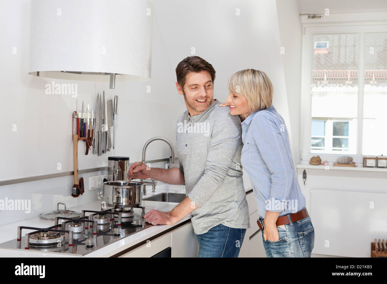 Germany, Bavaria, Munich, Mature couple preparing food in kitchen Banque D'Images
