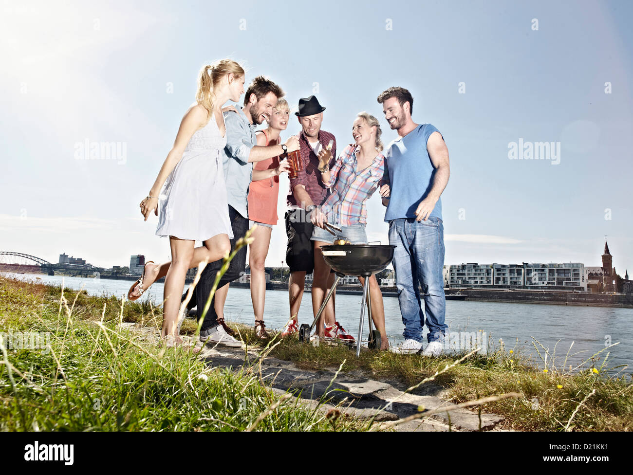 Allemagne, Cologne, groupe de personnes rassemblées autour d'un barbecue Banque D'Images