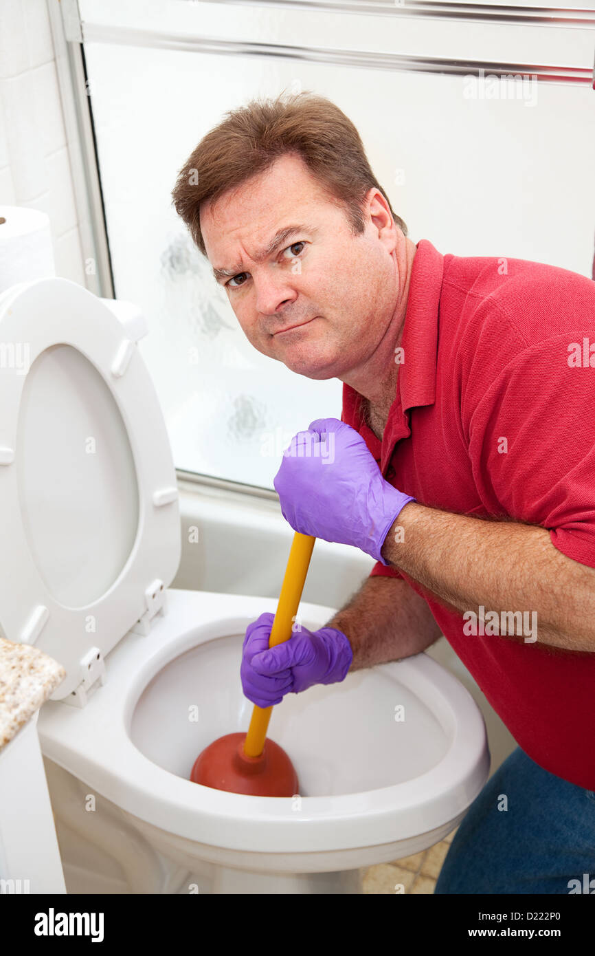 L'homme n'est pas heureux d'avoir à utiliser un piston pour déboucher les  toilettes Photo Stock - Alamy