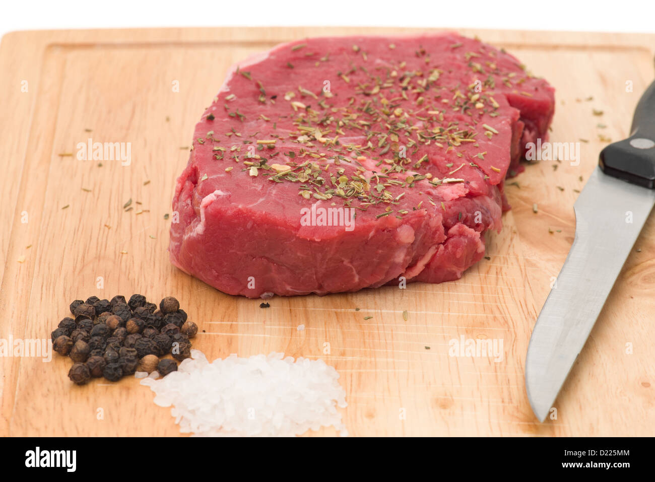Tranche de pavé de rumsteak sur une planche à découper en bois - studio photo avec un fond blanc Banque D'Images