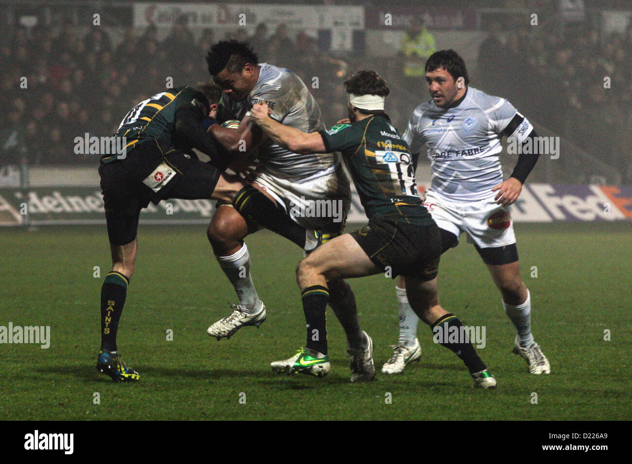 11.01.2013 Northampton, Angleterre.Iosefa TEKORI de Castres Olympique est abordé par Stephen MYLER (à gauche) et Dom WALDOUCK (droite) de Northampton Saints au cours de la Heineken Cup match entre Northampton Saints et Castres Olympique à Franklin's Gardens. Score final : Northampton Saints 18-12 Castres Olympique. Banque D'Images