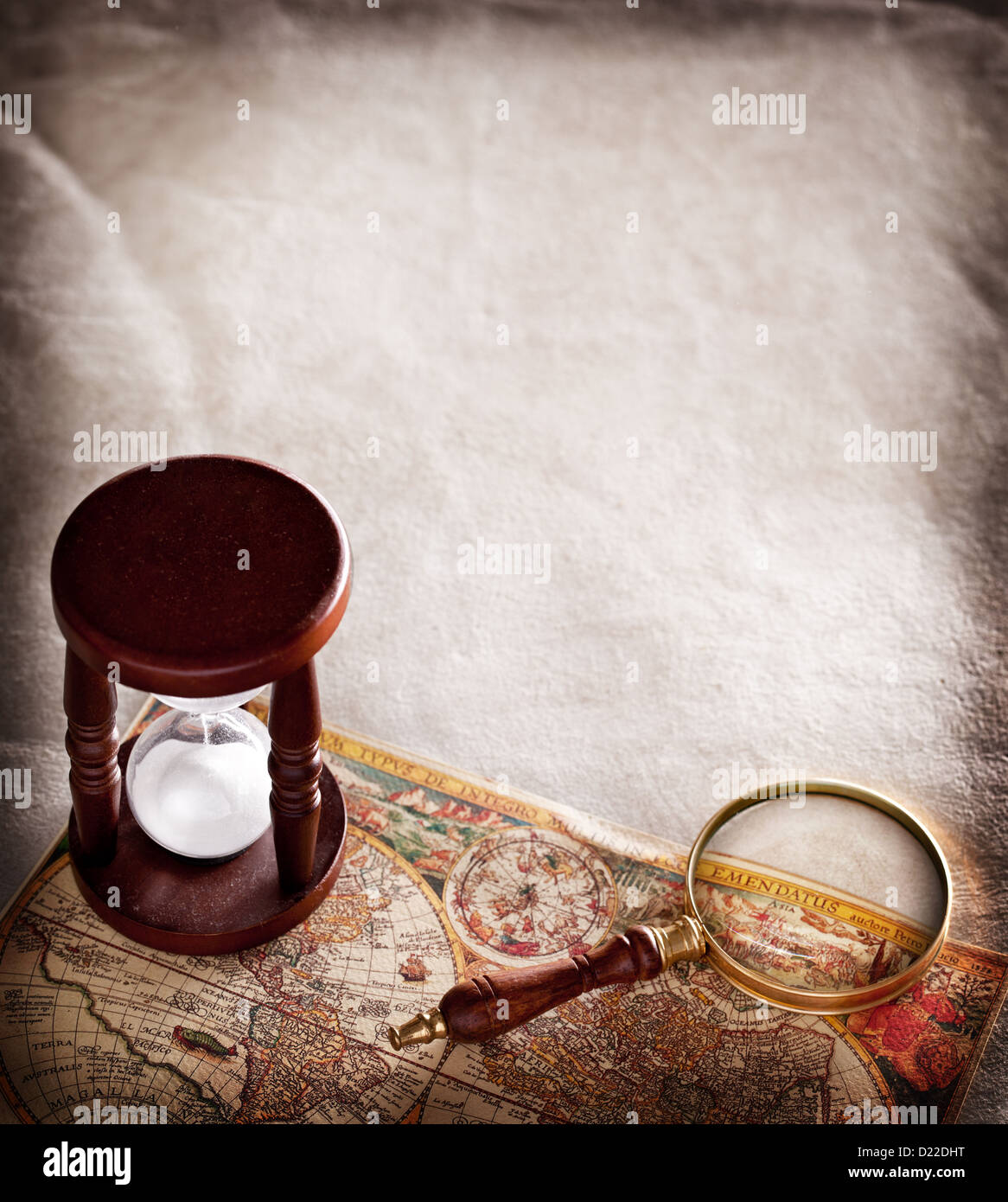 Hourglass avec une loupe sur du vieux parchemin. Banque D'Images