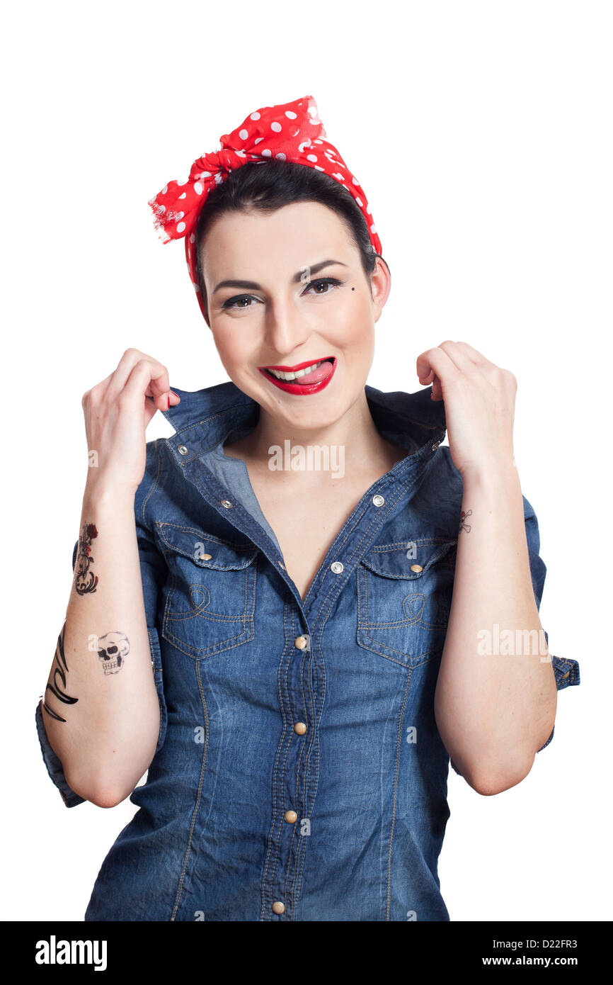 Femme en chemise en jean avec capeline rouge montrant la langue en souriant Banque D'Images