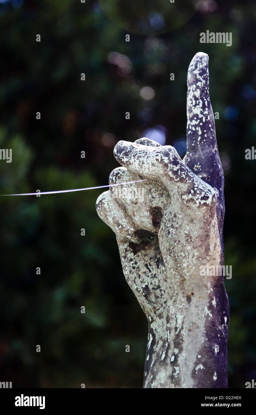 L'index d'une sculpture pointe vers le haut avec Spider web thread / la soie d'araignée Banque D'Images