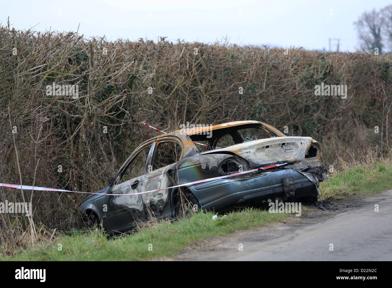 Voiture brûlée sur une voie rurale Banque D'Images