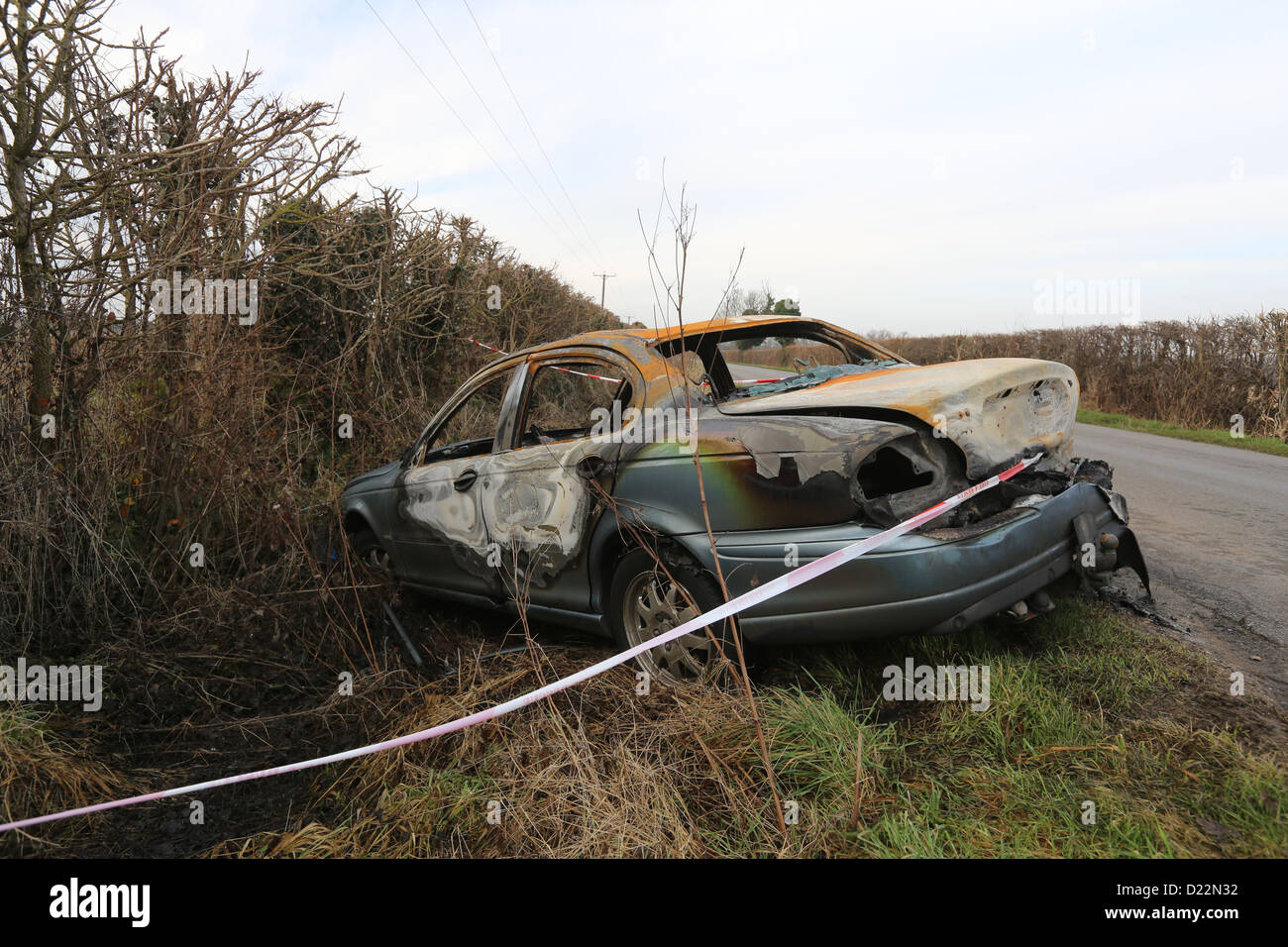 Voiture brûlée sur une voie rurale Banque D'Images