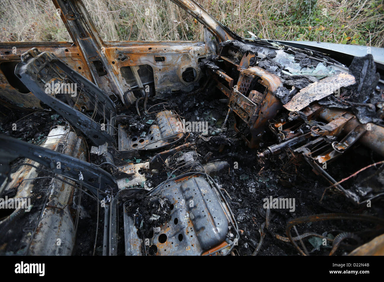 Voiture brûlée sur une voie rurale Banque D'Images