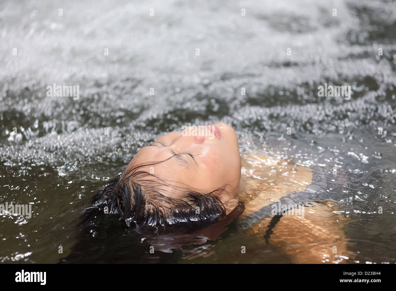Woman enjoying prendre un bain dans une piscine sauvages naturelles Banque D'Images