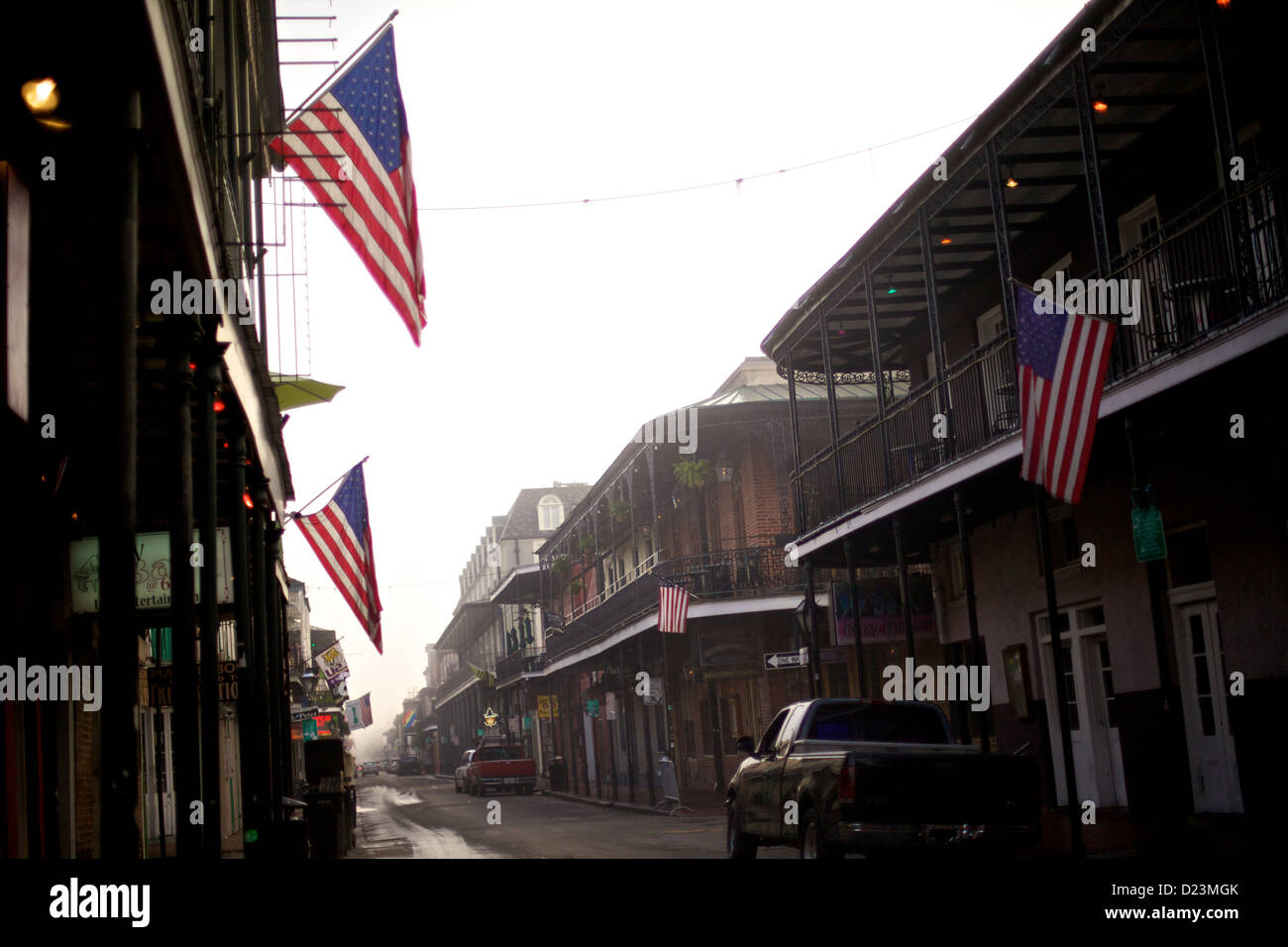 Vue matinale des drapeaux américains bordant les rues du quartier français, Nouvelle-Orléans, Louisiane, avec lumière douce, balcons historiques, et charme classique du sud Banque D'Images