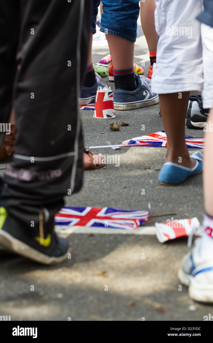 Drapeaux de l'Union mis au rebut sont foulés aux pieds comme les gens quittent une célébration du jubilé de la Reine Banque D'Images