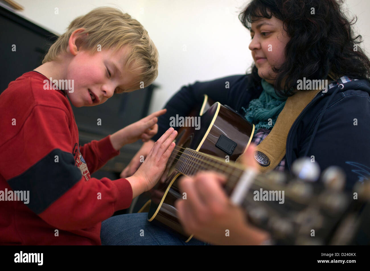 Presque aveugle huit ans, Mario et professeur de musique Claudia Geist  jouer la guitare à l'école pour les aveugles et malvoyants dans Lac  Neukloster See, Allemagne, 10 janvier 2013. Experts se réunira