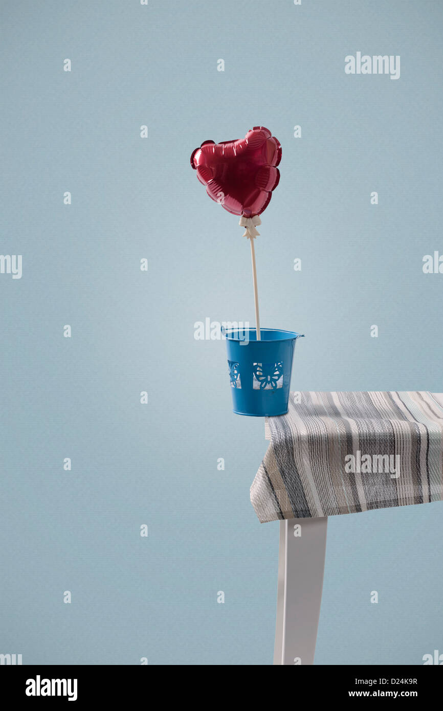 Un ballon en forme de coeur en équilibre sur le bord d'une table Banque D'Images