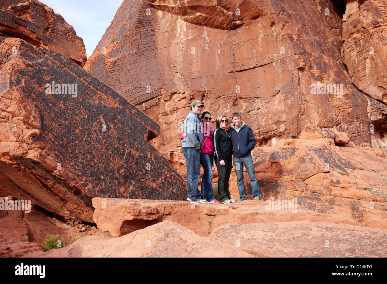 Les touristes posent devant des pétroglyphes sur atlatl rock grand Valley of Fire State Park nevada usa Banque D'Images