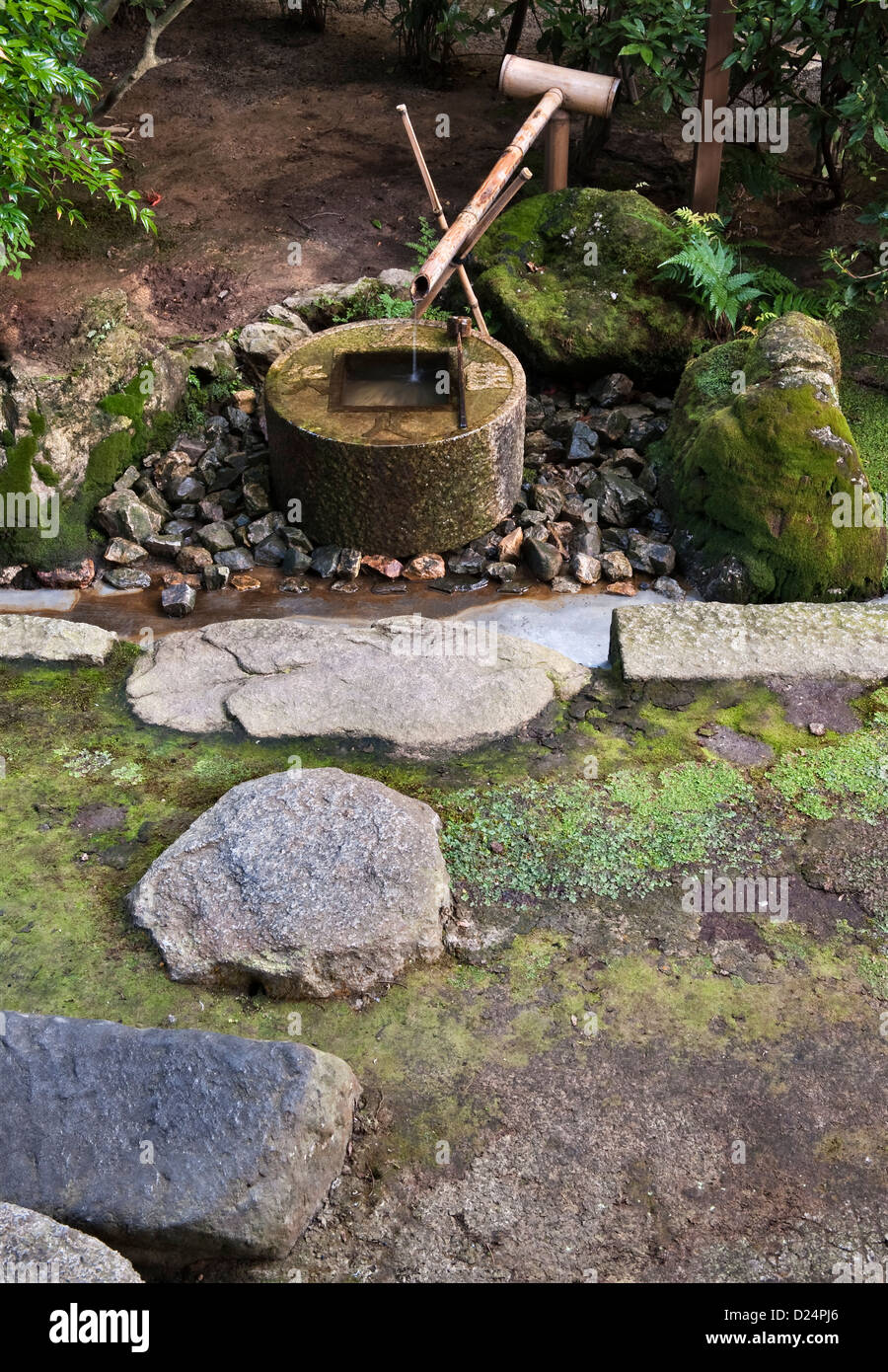 Une pierre tsukubai ou un bassin d'eau pour le lavage rituel ou la purification, dans le jardin du célèbre temple bouddhiste Zen de Ryoan-ji, Kyoto, Japon Banque D'Images