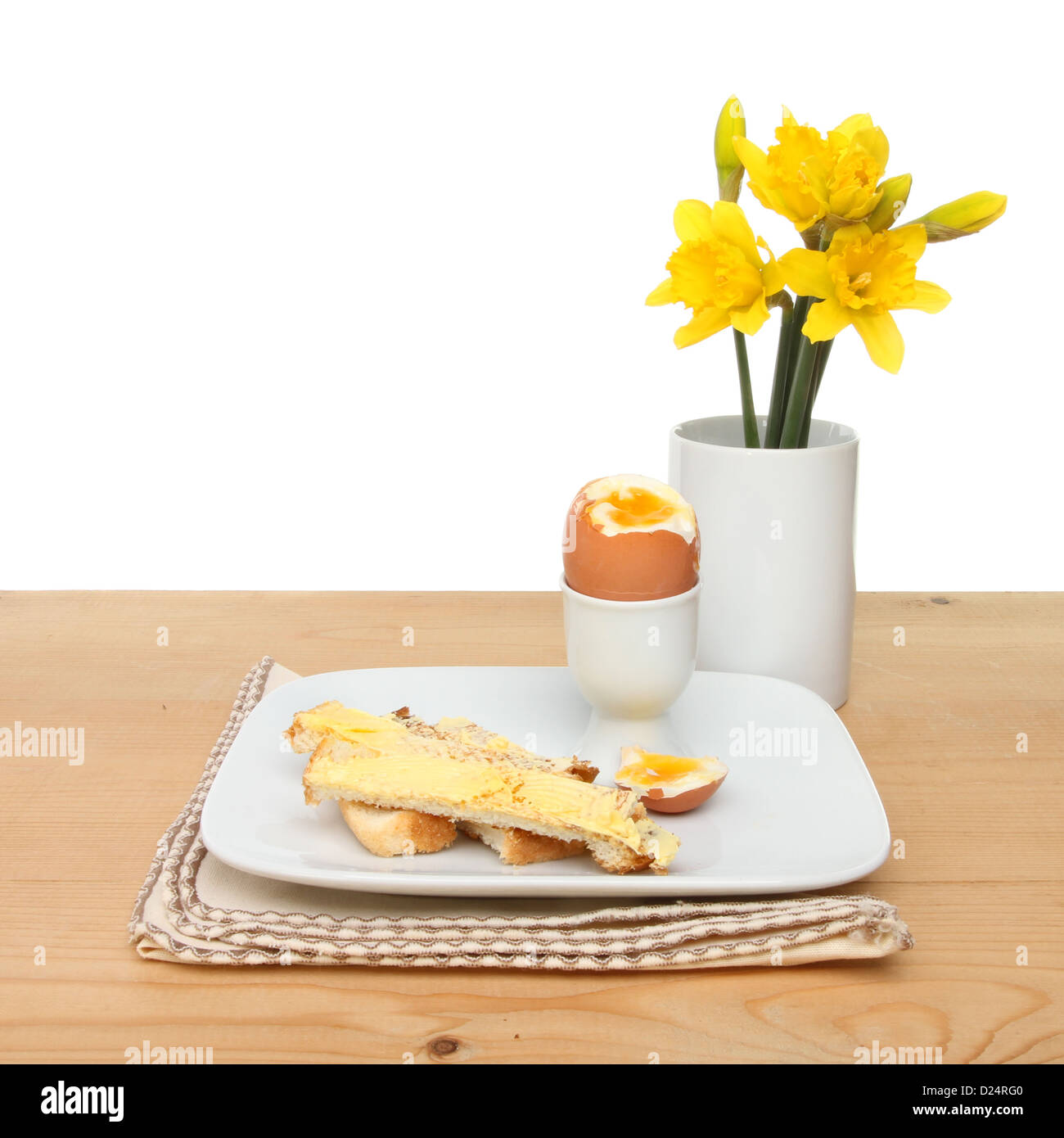 Thème de Pâques ou du printemps, œuf à la coque, de pain grillé et de fleurs jonquille soldats sur une table Banque D'Images