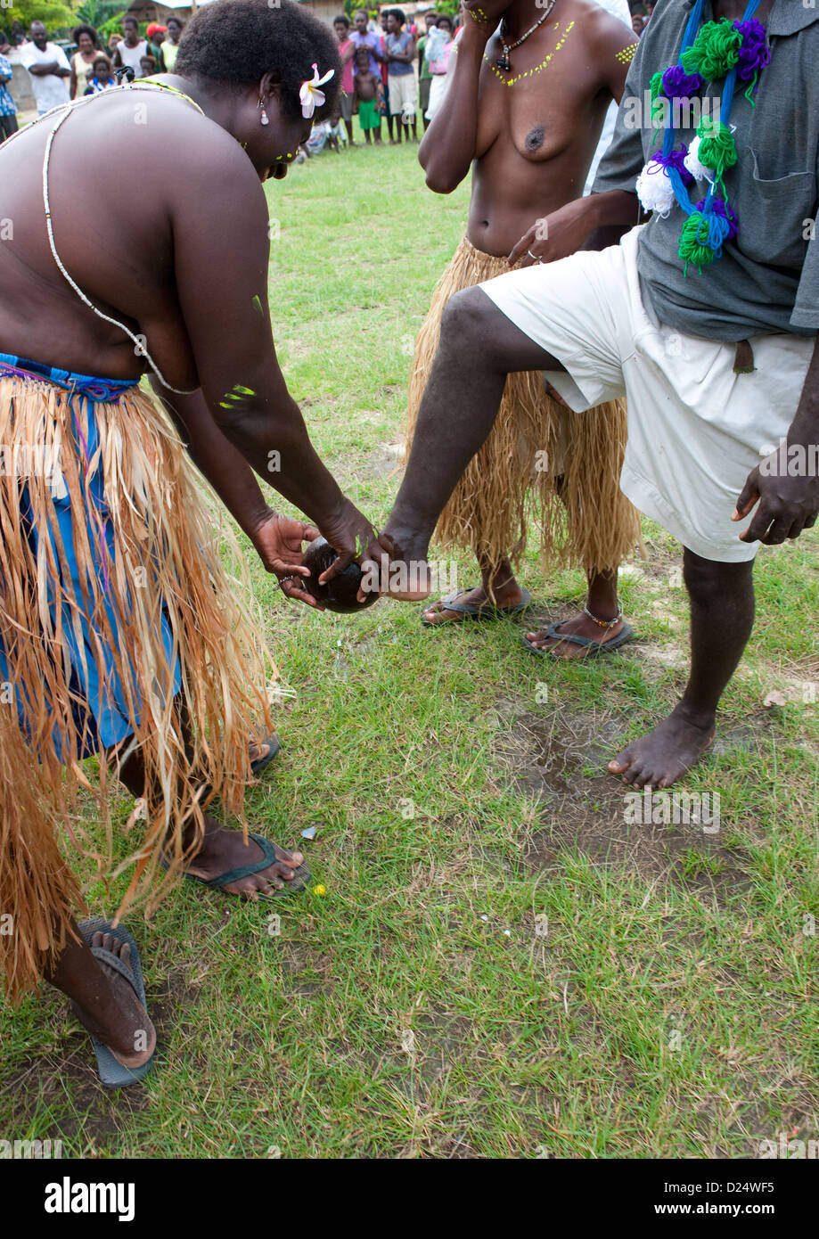Femme l'accueil des visiteurs en leur lavant les pieds, Bougainville, en Papouasie-Nouvelle-Guinée Banque D'Images