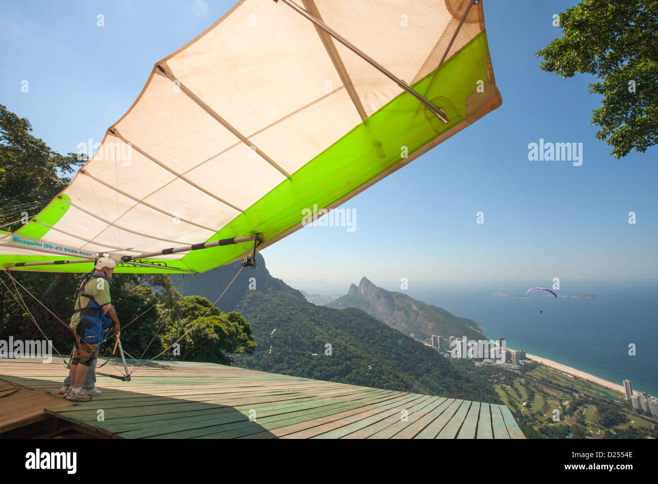 Brésil, Rio, forêt de Tijuca, deltaplane se préparant à partir à Pedra Bonita rock au-dessus de la plage de Sao Conrado. Vue sur la plage et l'océan Atlantique Banque D'Images