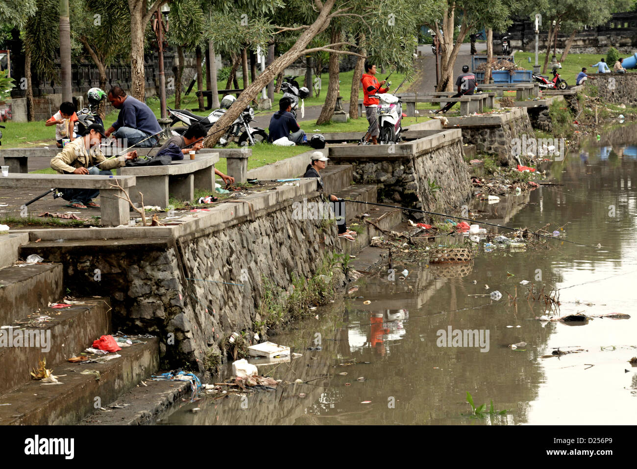Les ordures de Bali : de la rivière à la mer, les gens de la pêche dans l'eau polluée. Banque D'Images