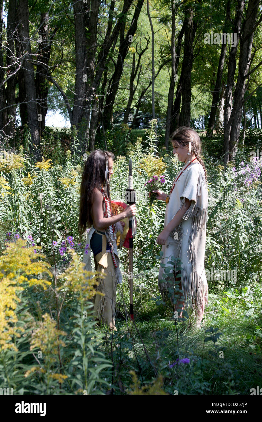 Native American Indian boy and girl in the woods partager un moment romantique Banque D'Images