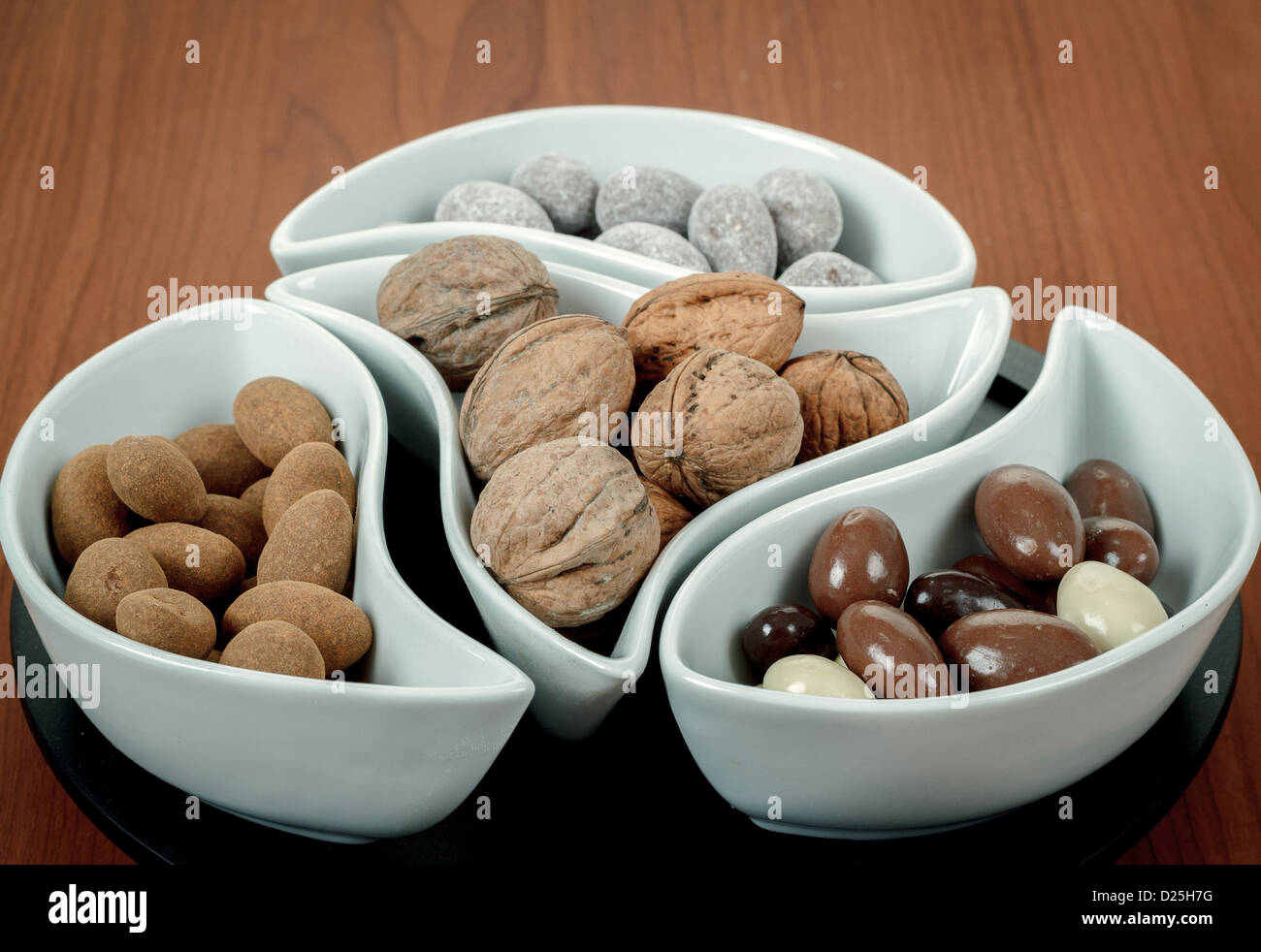 Les amandes dans le chocolat et les noix sur woden background Banque D'Images