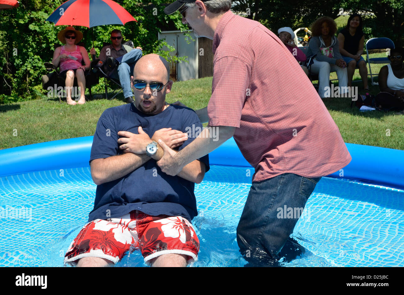 Homme obtient baptisé à une piscine extérieure à Riverdale Park, MD Banque D'Images