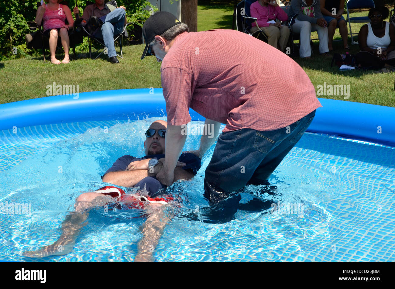 Homme obtient baptisé à une piscine extérieure à Riverdale Park, MD Banque D'Images
