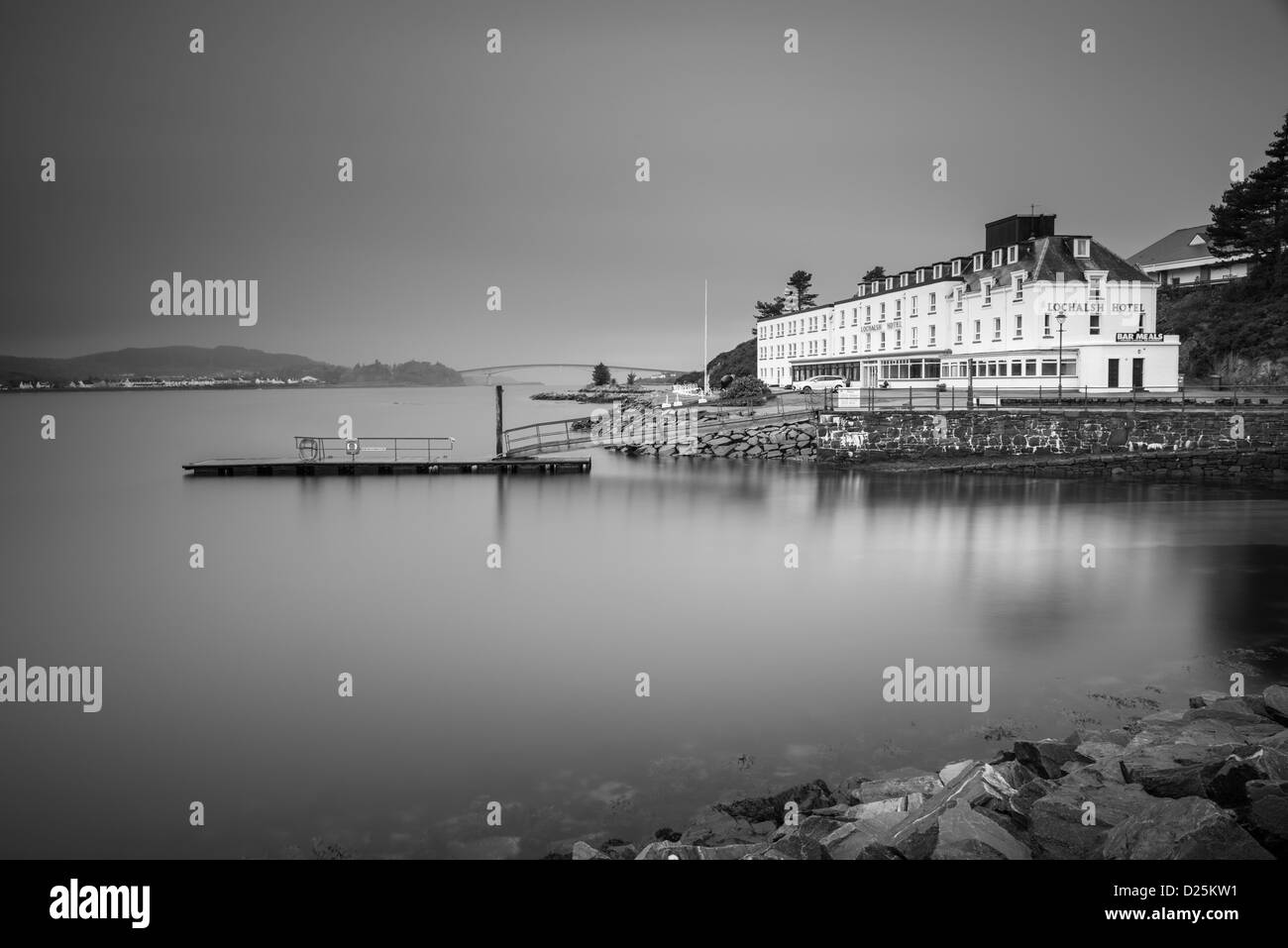 Le pont de Skye photographié dans une longue exposition de Kyle of Lochalsh avec l'hôtel et le quai à l'avant-plan Banque D'Images