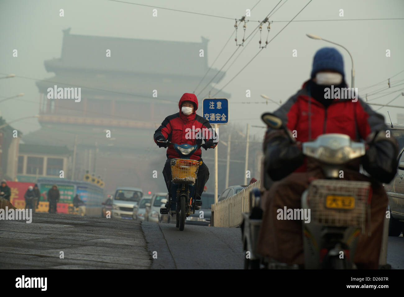 L'homme porte un masque dans le smog lourd en face de la tour du tambour à Beijing, Chine. 14-Jan-2013 Banque D'Images