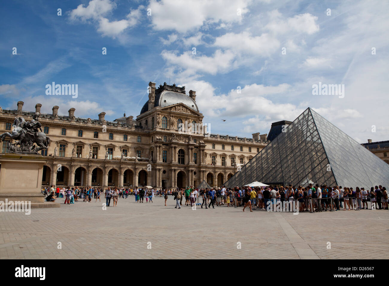 Palais du Louvre avec sa pyramide gate et les touristes d'attendre en file pour entrer. Paris, France Banque D'Images