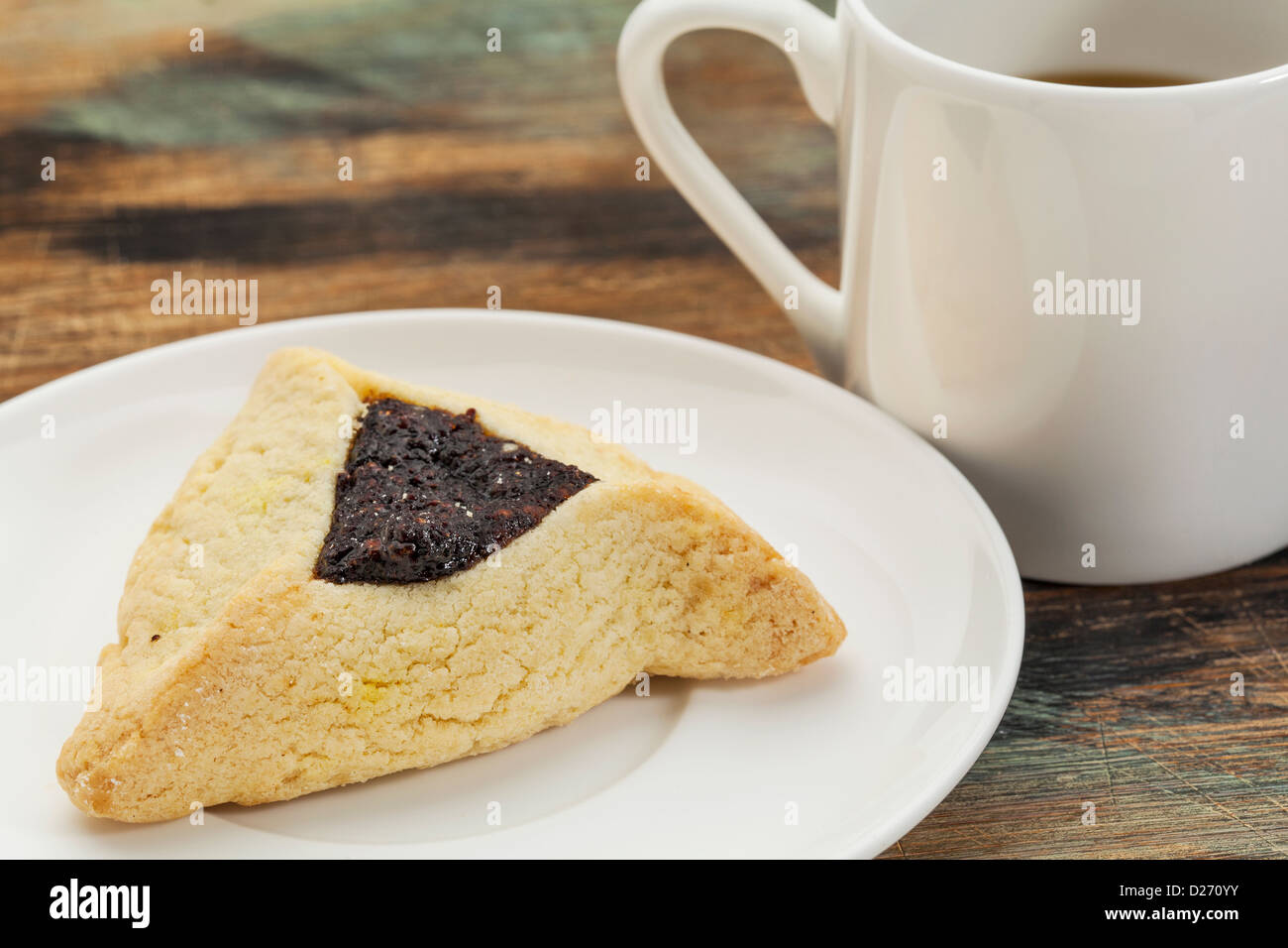 Cookie hamantaschen fruits sur une plaque avec une tasse de café Banque D'Images