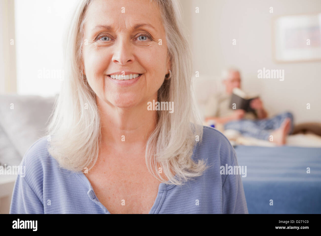 Senior woman smiling with mari lecture en arrière-plan Banque D'Images