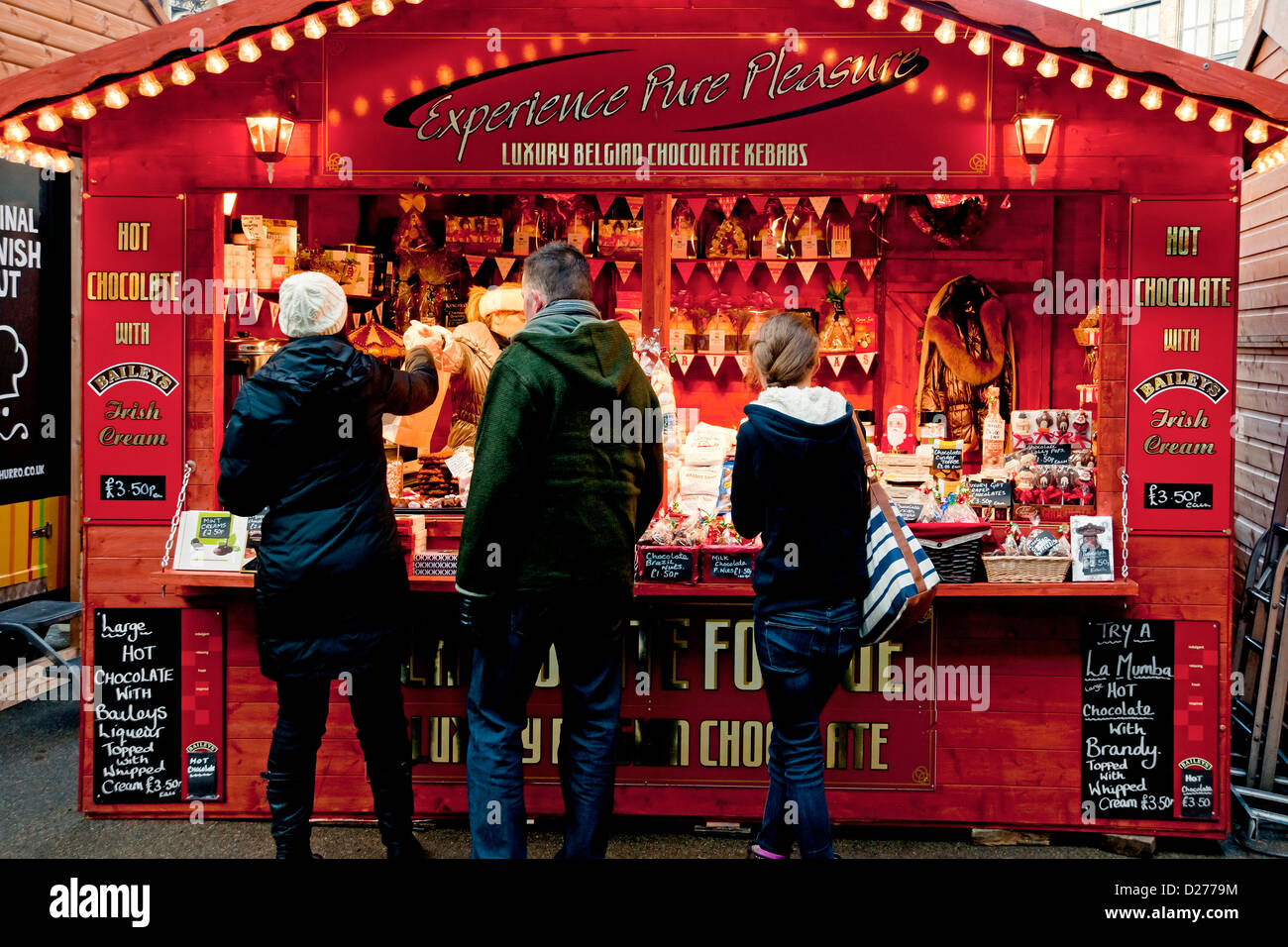 Gens touristes visiteurs au marché de Noël stand de vente de chocolat dans Winter York North Yorkshire Angleterre Royaume-Uni GB Grande Grande-Bretagne Banque D'Images
