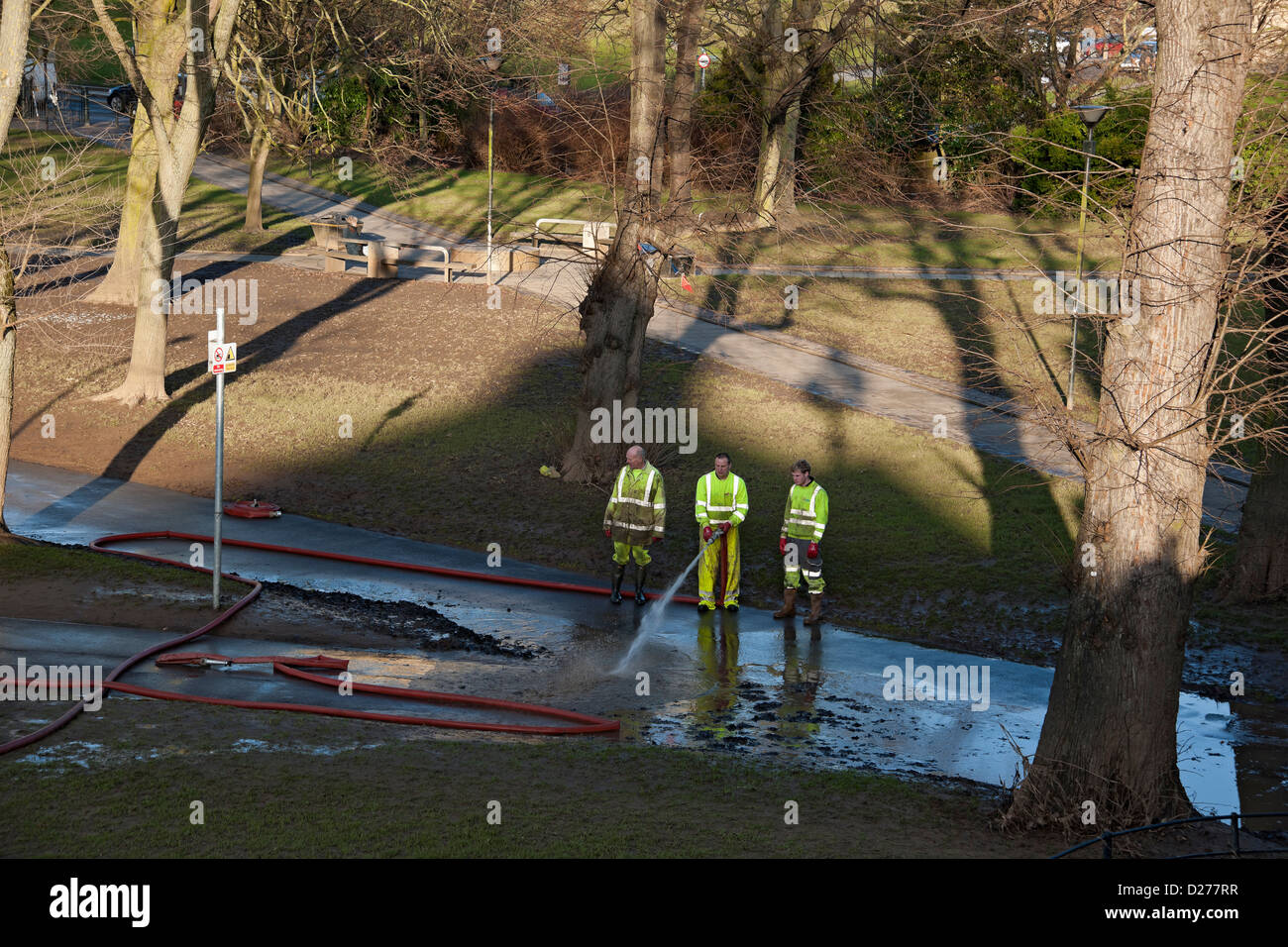 Les travailleurs du Conseil nettoyent la boue de travail du sentier pédestre après les inondations en hiver York North Yorkshire Angleterre Royaume-Uni Grande-Bretagne Banque D'Images