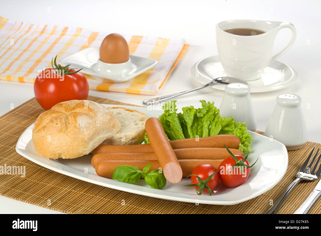 Petit-déjeuner saucisses, tomates, oeufs, et une tasse de thé Banque D'Images