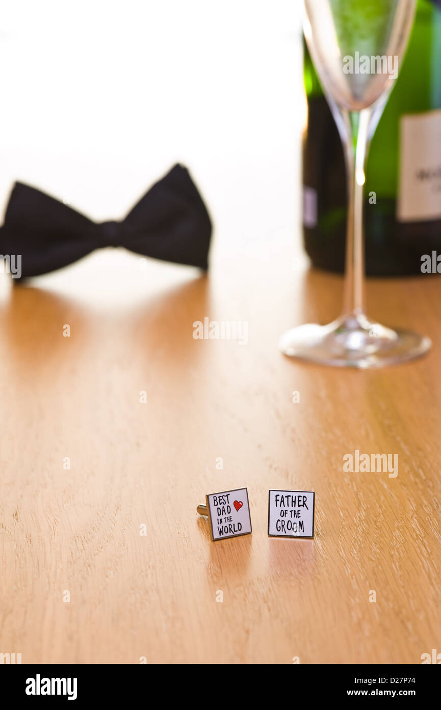 Noeud papillon et les boutons de manchette sur une table avec une bouteille de champagne et le verre. Banque D'Images